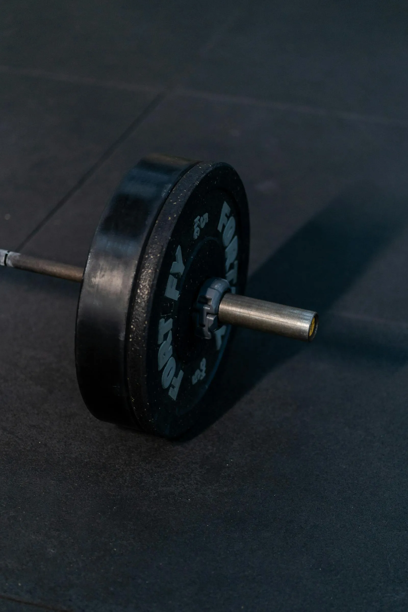 Close-up of a loaded barbell with weight plates on a gym floor