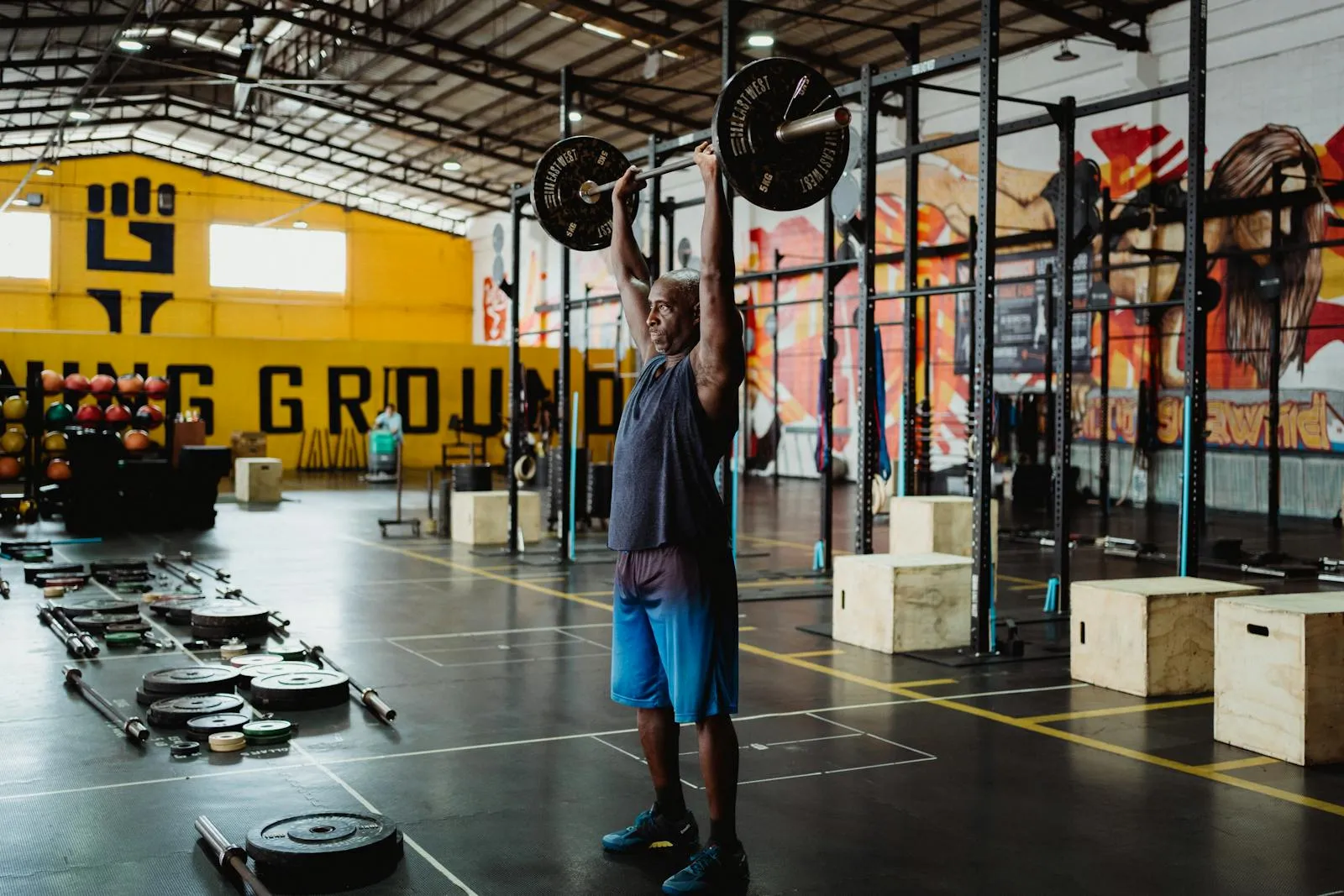 A lifter performs a heavy barbell exercise in a well-equipped gym